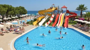 Rodzina z dziećmi w aquaparku tureckiego hotelu - dzieci zjeżdżają po zjeżdżalni wodnej