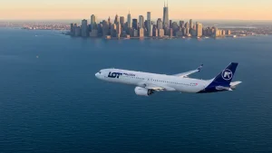 Samolot LOT lecący nad oceanem, widok z góry na Nowy Jork, Chicago i Los Angeles w tle