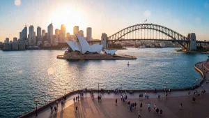 Widok na Opera House i Harbour Bridge w Sydney o zachodzie słońca z błękitnym morzem